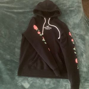 Black with flowers on sides of arms Hollister hoodie size Small.